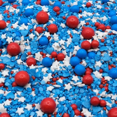 Confeitos para bolos coloridos em azul, vermelho e branco com formas variadas.