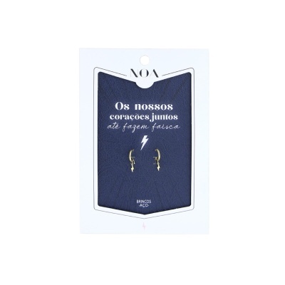 Brincos de aço dourado em cartão com texto em português e detalhe de raio.