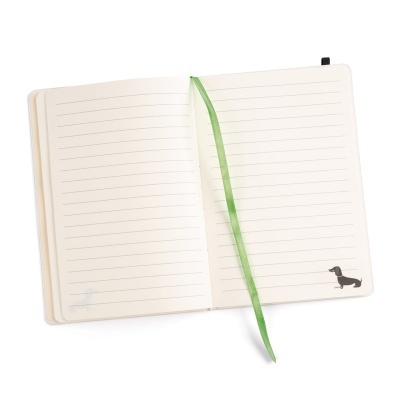 Caderno aberto com páginas pautadas e marcador verde