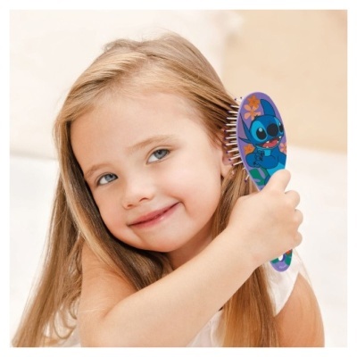 Menina loira a escovar o cabelo com escova azul com Stitch