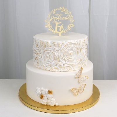 Bolo de duas camadas branco com flores em relevo e texto dourado no topo