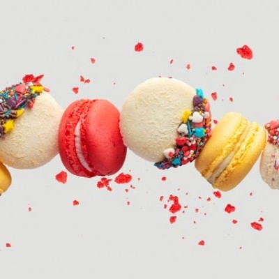 Seis macarons coloridos com decoração de granulado colorido em fundo branco