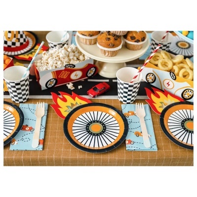 Mesa decorada para festa infantil com pratos e copos de papel com temas de corrida, caixas de pipoca e snacks, e decoração colorida