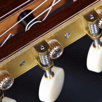 Detalhe das tarraxas e cordas de guitarra clássica em madeira castanha