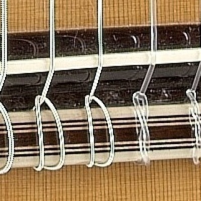 Detalhe de persiana de rolo com tiras em tecido bege, preto e branco e mecanismos de corda