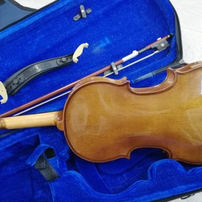 Violino castanho brilhante com arco dentro de estojo azul aberto