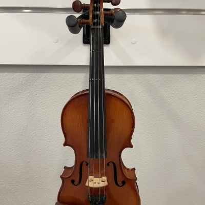 Violino de madeira castanha pendurado numa parede branca com suporte preto