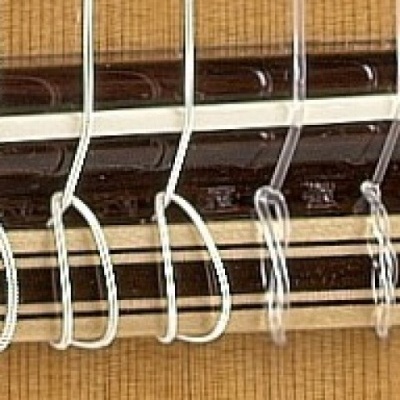 Cordas de nylon de guitarra clássica com madeira clara ao fundo