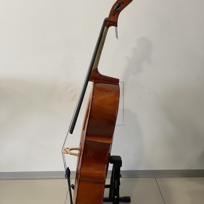 Violino de madeira castanho num suporte preto com fundo de parede branca