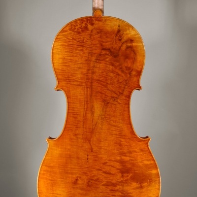 Parte traseira de violoncelo em madeira laranja-acastanhada com textura visível