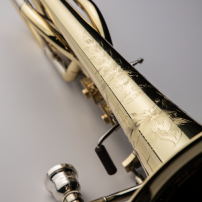 Trompete dourado com gravações florais e bocal prateado