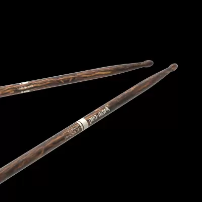 Par de baquetas para bateria em madeira escura com texto Pro-Mark e Firegrain