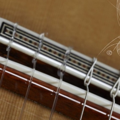 Cordas de guitarra clássica em madeira clara com decoração geométrica preta e branca
