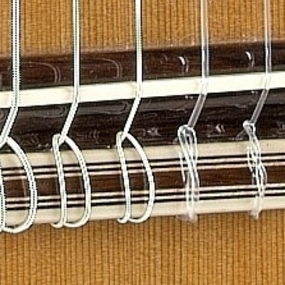 Pano ou tapete castanho com riscas pendurado por ganchos brancos numa barra