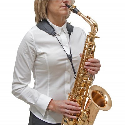 Mulher a tocar saxofone tenor dourado com correia preta