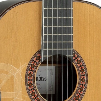 Guitarra clássica de madeira clara com padrão circular colorido à volta da boca