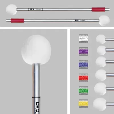 Baquetas de bateria com cabo metálico, punho vermelho e pontas brancas macias, com etiquetas de dureza coloridas.