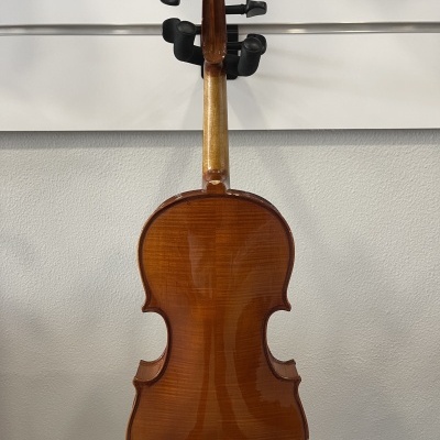 Violino de madeira castanha pendurado numa parede branca