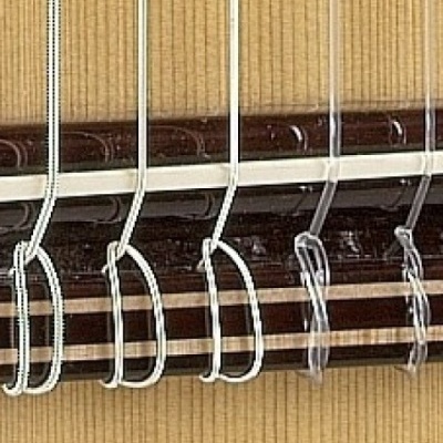 Correntes metálicas prateadas penduradas numa barra escura com fundo bege riscado