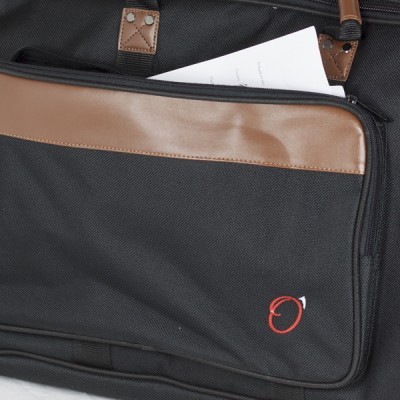 Mala preta com detalhes em couro castanho e bolso frontal com papel branco