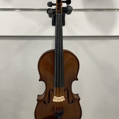 Violino castanho de madeira com quatro cordas e cavalete em madeira clara