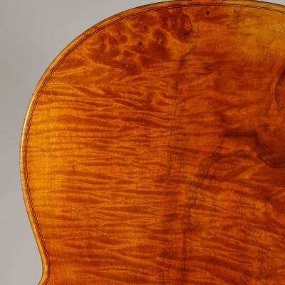 Traseira de violino em madeira castanho-avermelhada com textura visível