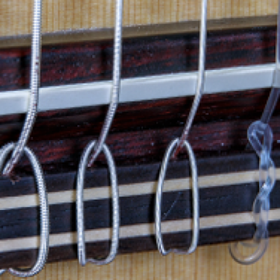 Parte de guitarra com cordas metálicas e proteção plástica