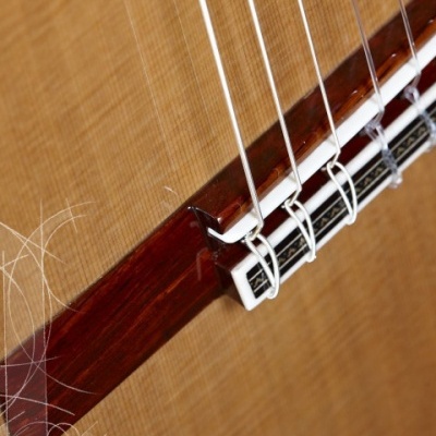 Ponte de guitarra clássica em madeira com cordas de nylon brancas