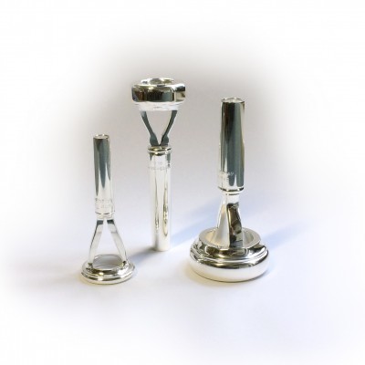 Conjunto de três objetos metálicos prateados sobre fundo branco