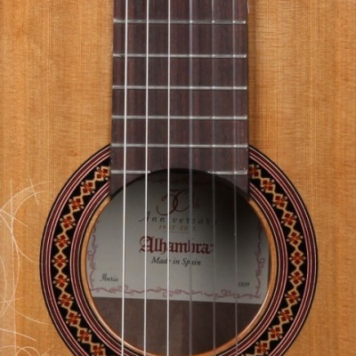 Guitarra clássica em madeira clara com etiqueta 'Alhambra Made in Spain' e padrão decorativo no bocal