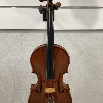 Violino em madeira castanho-avermelhada pendurado numa parede branca