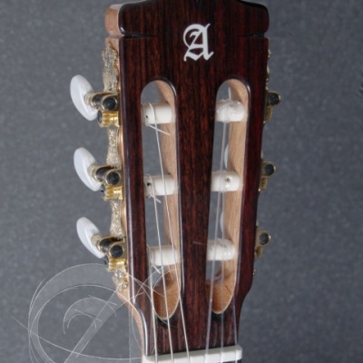 Cabeçote de guitarra clássica de madeira escura com letra A branca