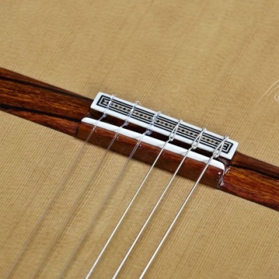 Tampo de guitarra clássica mostrando ponte com detalhes e cordas