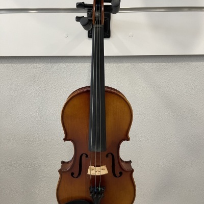 Violino castanho pendurado numa parede branca