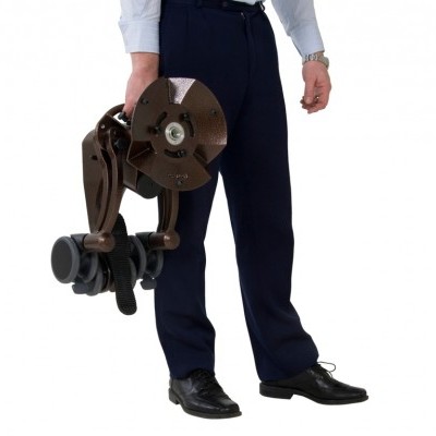 Pessoa a segurar peça mecânica metálica castanha com rodas, em fundo branco