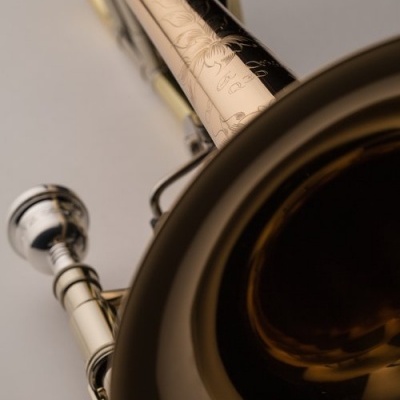 Trompete dourado com bocal prateado e detalhes gravados