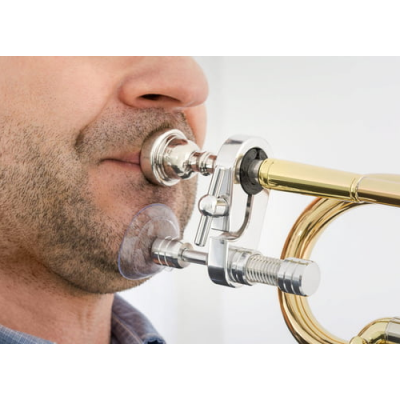 Pessoa a tocar uma corneta dourada com boquilha prateada