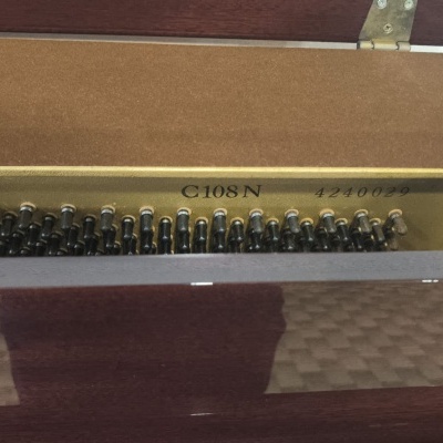 Interior de piano com estrutura metálica dourada e cordas