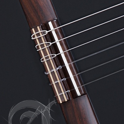 Parcial da guitarra clássica preta com ponte de madeira e cordas metálicas