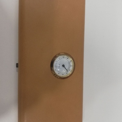 Caixa castanho clara com termómetro analógico circular no centro da tampa