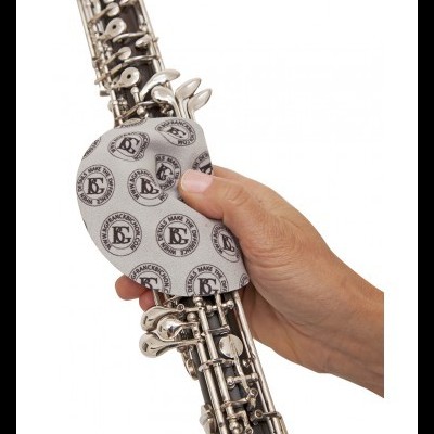 Clarinete preto com chaves prateadas e almofada protetora branca estampada, segurado por mão direita.