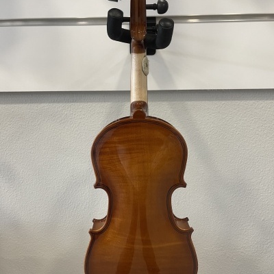 Violino castanho brilhante visto de costas num suporte na parede