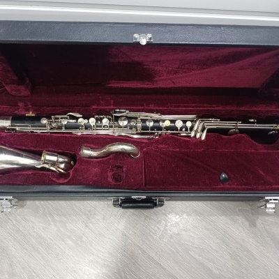 Estojo preto aberto com forro vermelho e clarinete desmontado dentro