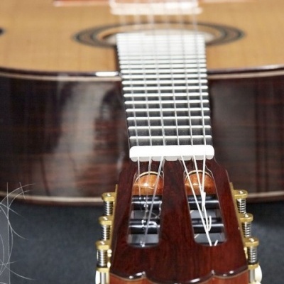 Guitarra clássica com madeira clara e escura, cordas de nylon e tarraxas douradas