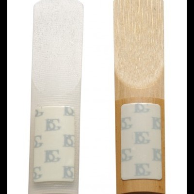 Dois palhetões de clarinete, um de madeira clara e um branco com padrão azul