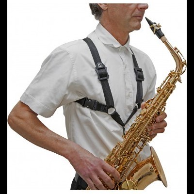 Homem com camisa branca a tocar saxofone dourado com alça preta