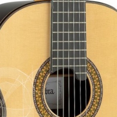 Parte central de uma guitarra clássica de madeira clara com detalhe decorativo circular