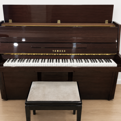 Piano vertical de madeira castanha escura YAMAHA com banco estofado bege