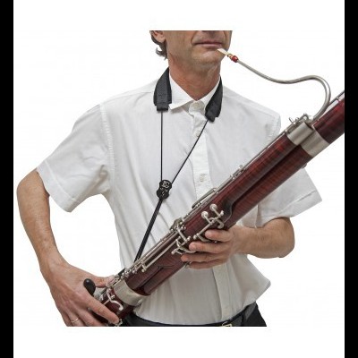 Homem a tocar fagote de madeira escura com chaves metálicas prateadas