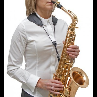 Mulher a tocar saxofone alto dourado com alça preta